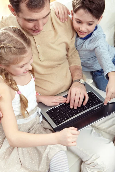 Família feliz usando laptop juntos — Fotografia de Stock