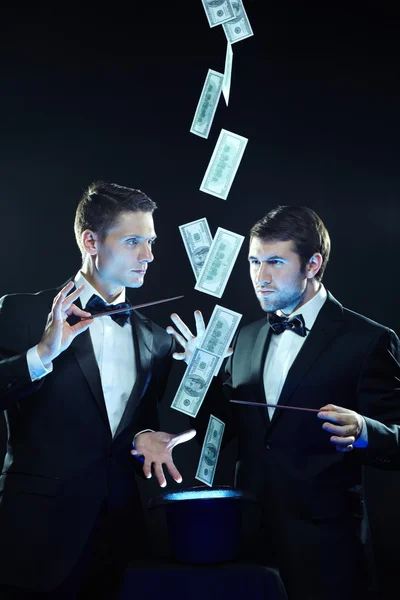 Magicians making money fly out of hat — Stock Photo, Image