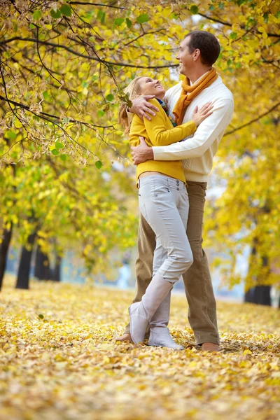 Пара, обнимающая осенние деревья — стоковое фото
