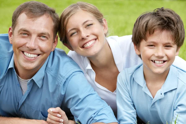 Happy family lying in grass — Stock Photo, Image