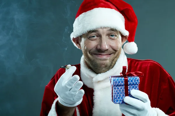 Stoned Santa Claus with a gift box — Stock Photo, Image