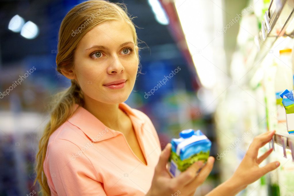 Woman with carton of milk in the grocery