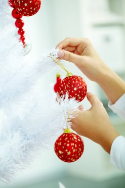 Kırmızı topları Noel ağacı üzerinde asılı el