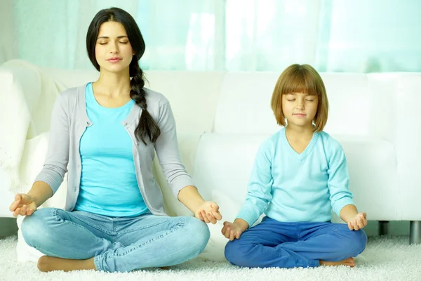 Мать с дочерью медитируют вместе — стоковое фото