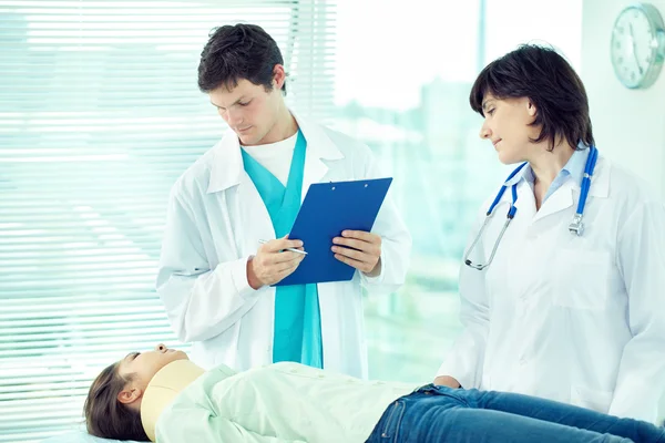 Two doctors examining patient in hospital — Stock Photo, Image