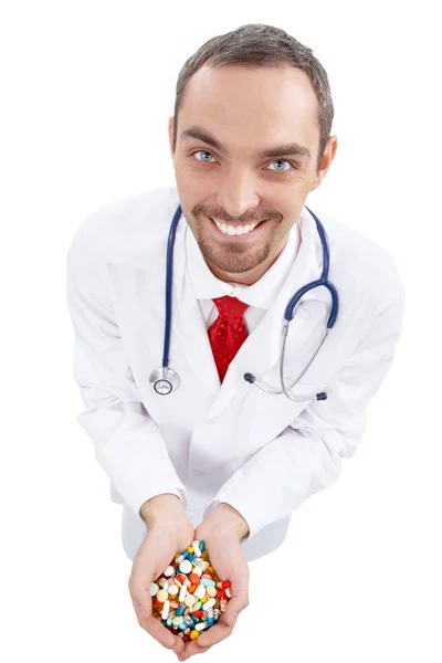 Улыбающийся доктор с горсткой таблеток — стоковое фото