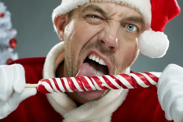 Aggressive Santa sucking a lollipop — Stock Photo, Image