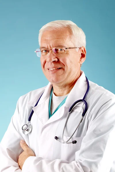 Уверенный старший врач смотрит в камеру — стоковое фото