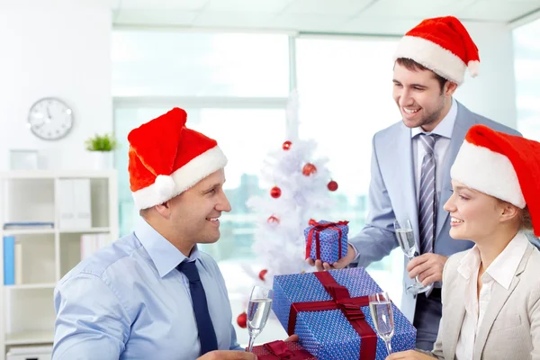 Compañeros de negocios intercambian cajas de regalo en la oficina —  Fotos de Stock