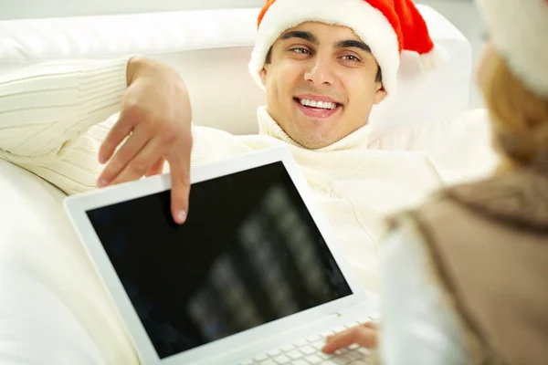 Man in Christmas hat pointing at screen — Stock Photo, Image