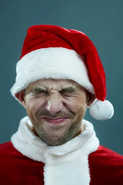 Wincing man in Santa's clothing — Stock Photo, Image