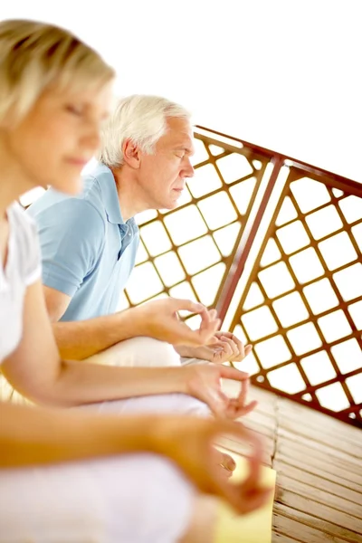 Mature couple mediating on veranda — Stock Photo, Image