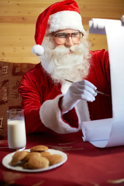 Santa Claus drawing something on paper — Stockfoto