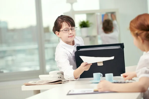 Office worker giving documents to her colleague — Stock Photo, Image