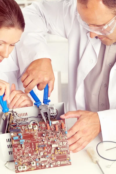 Eletricistas trabalhando com placa de circuito — Fotografia de Stock