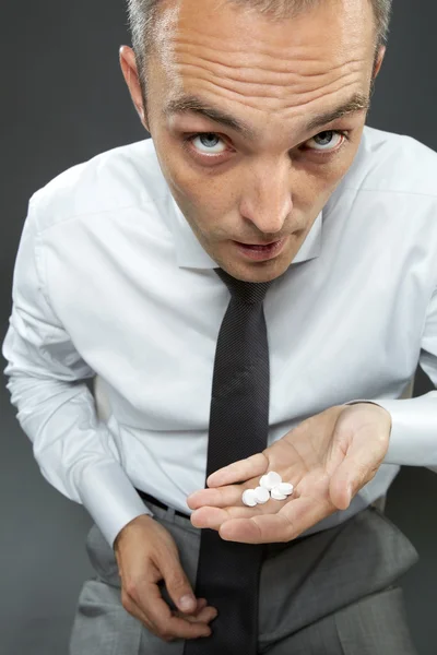 Businessman taking pills and looking at camera — Stock Photo, Image