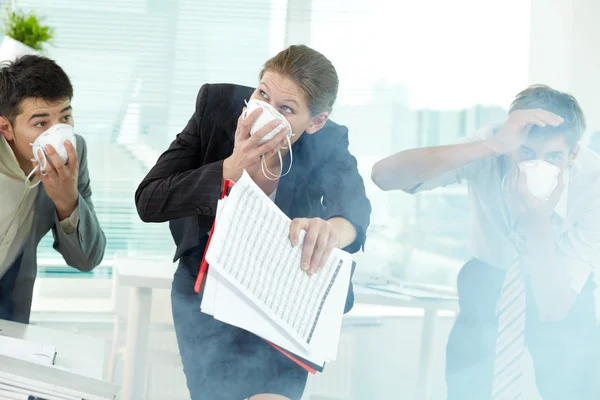 Mensen uit het bedrijfsleven in gasmaskers happend in kantoor — Stockfoto