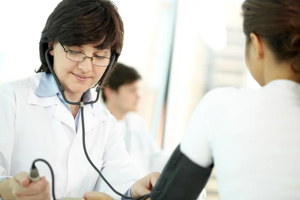 Dokter geven een bloeddruk-examen — Stockfoto