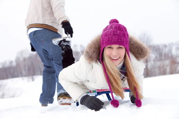 Young woman lying on sled — Stock Photo, Image