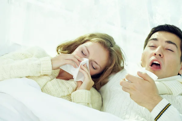Casal espirrando e soprando seus narizes — Fotografia de Stock