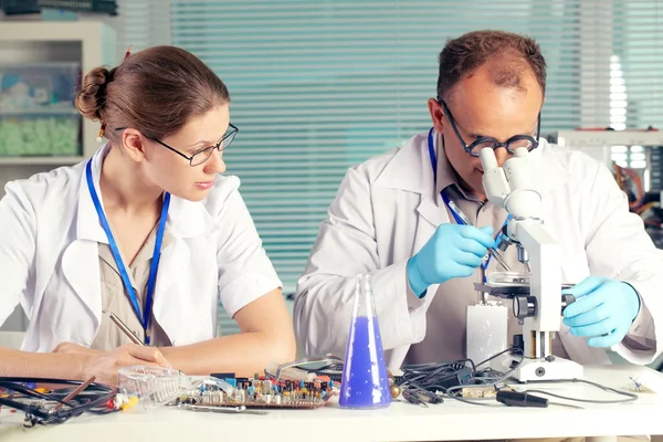 Técnicos que trabalham em conjunto na oficina — Fotografia de Stock