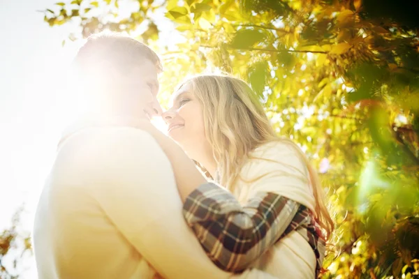 Gens heureux embrassant dans les rayons de soleil — Photo