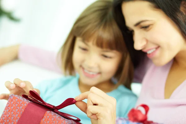 Madre e figlia che legano un nastro sulla confezione regalo — Foto Stock