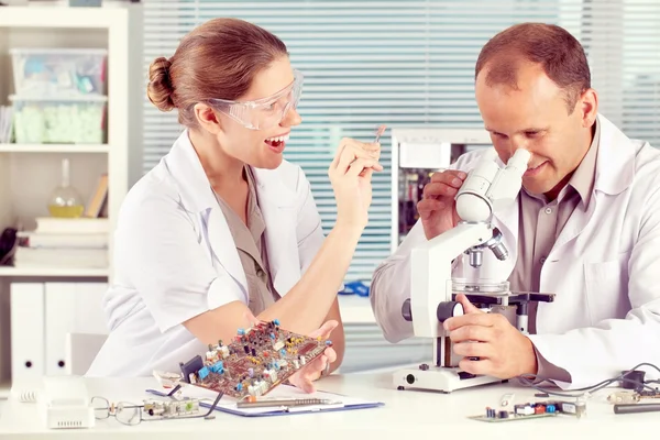 Frau zeigt ihrem Kollegen elektronische Details — Stockfoto