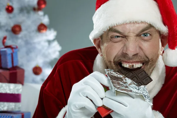 Wicked Santa Claus devouring chocolate — Stock Photo, Image