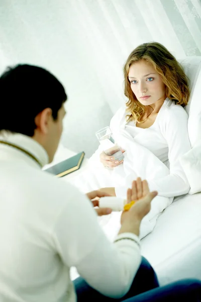 Marido dando remédio para sua esposa doente — Fotografia de Stock