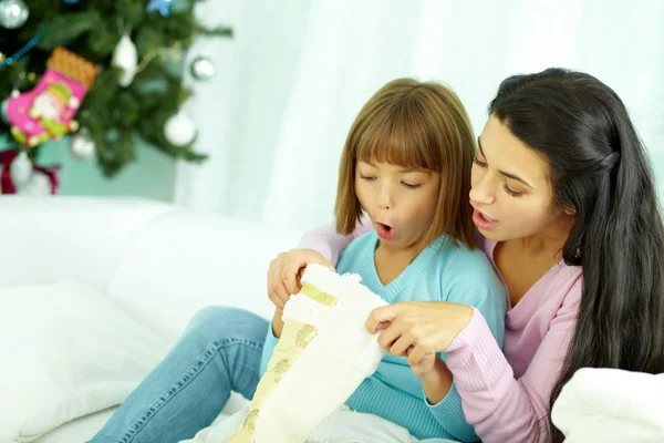 Mother and daughter looking into Christmas stocking — Stockfoto