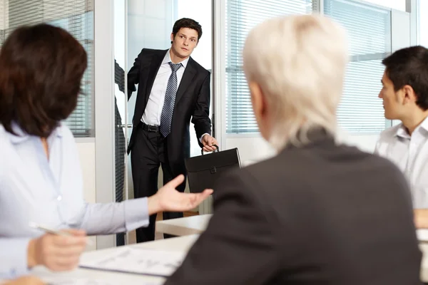 Un employé de bureau arrive en retard à une réunion — Photo