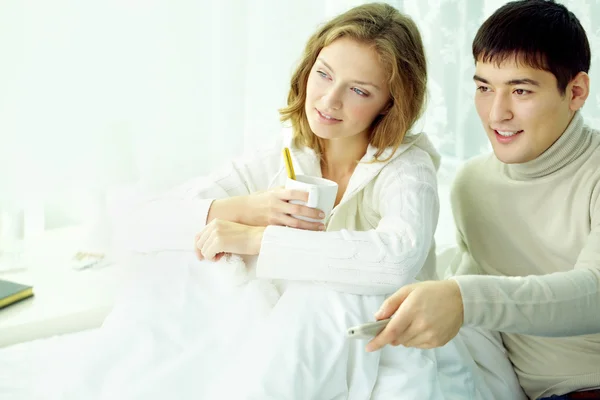 Pareja viendo la televisión en la cama — Foto de Stock