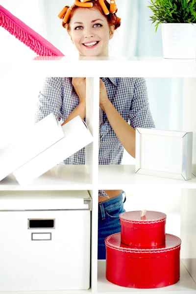 Happy housewife standing at shelves — Stock Photo, Image