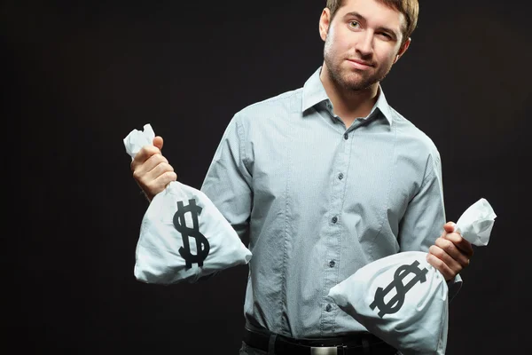 Homem de pé com dois sacos de dinheiro — Fotografia de Stock