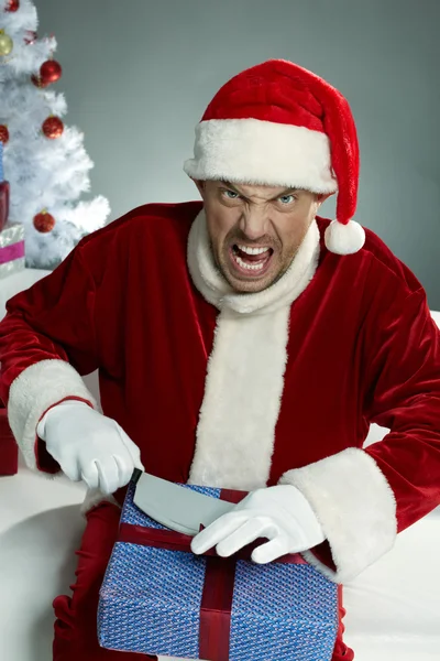 Evil Santa damaging gift boxes — Stock Photo, Image