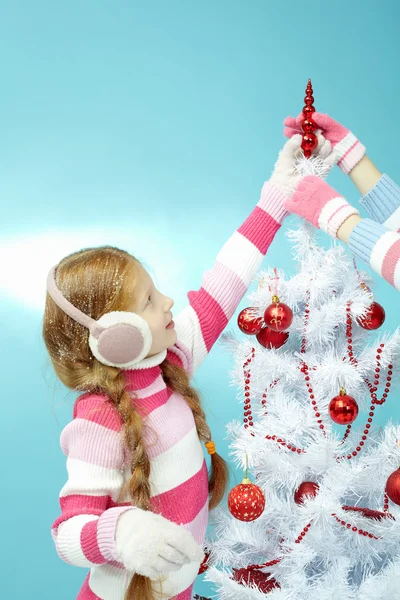 Girl decorating top of Christmas tree — Stockfoto