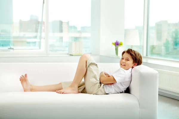Mały chłopiec spoczywający na kanapie — Zdjęcie stockowe