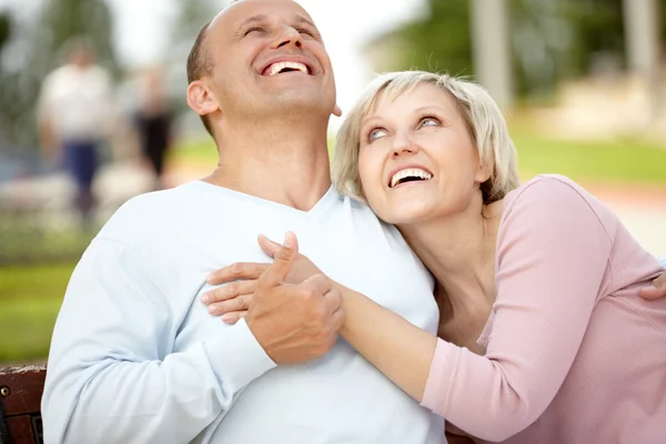 Mature couple embracing on bench — Stock Photo, Image