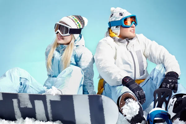 Snowboarders sitting on snow and resting — Stock Photo, Image