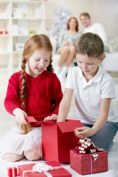 Kinder begutachten Weihnachtsgeschenkboxen — Stockfoto