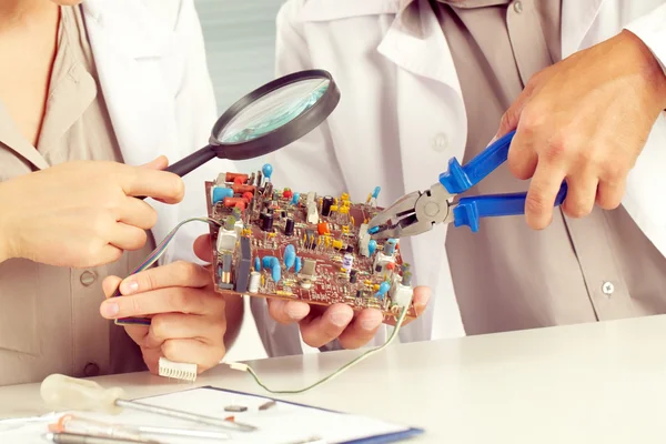 Ingenieros que trabajan con placa de circuito — Foto de Stock