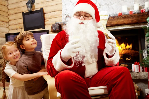 Санта-Клаус ест печенье с детьми — стоковое фото