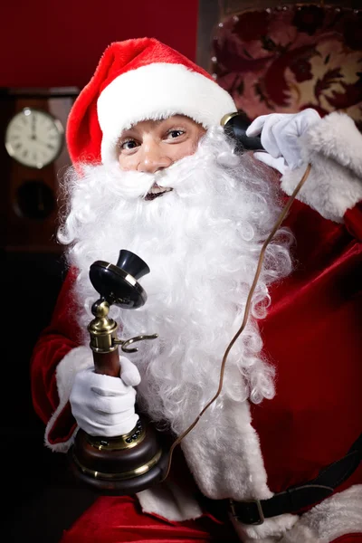 Weihnachtsmann im Gespräch am altmodischen Telefon — Stockfoto