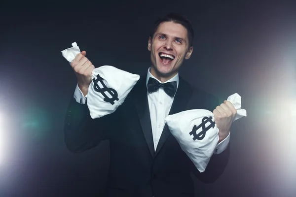 Mad businessman with two money bags — Stockfoto