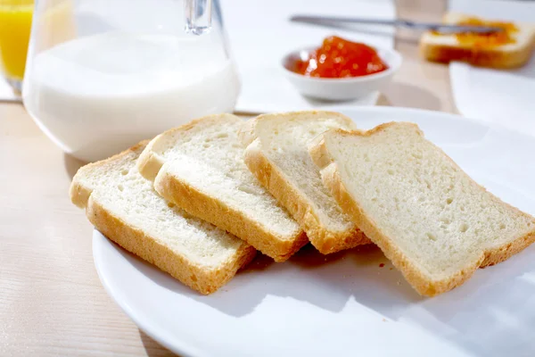 Frisches Scheibenbrot mit Krug Milch — Stockfoto