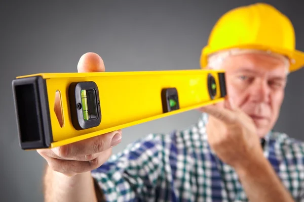 Senior constructor holding a ruler — Stock Photo, Image