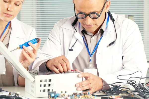 Laboratuarda çalışan kadın asistanı olan bilim adamı 