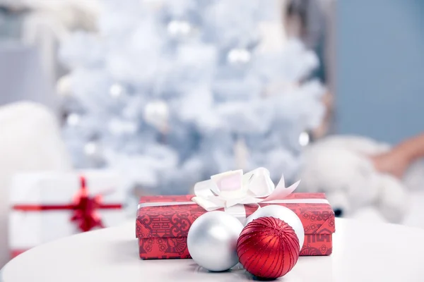 Kerstcadeau en kerstballen op tafel — Stockfoto