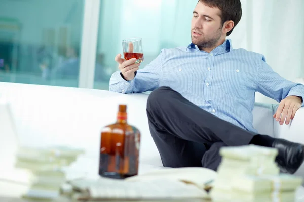 Man zit met glas cognac — Stockfoto